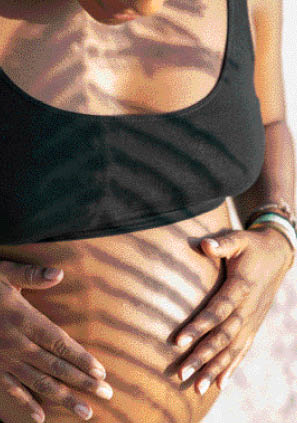 Pregnant woman holds belly.