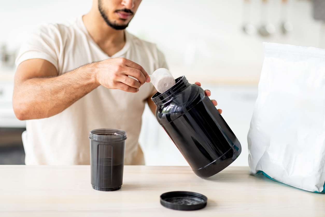 Man scooping protein powder.