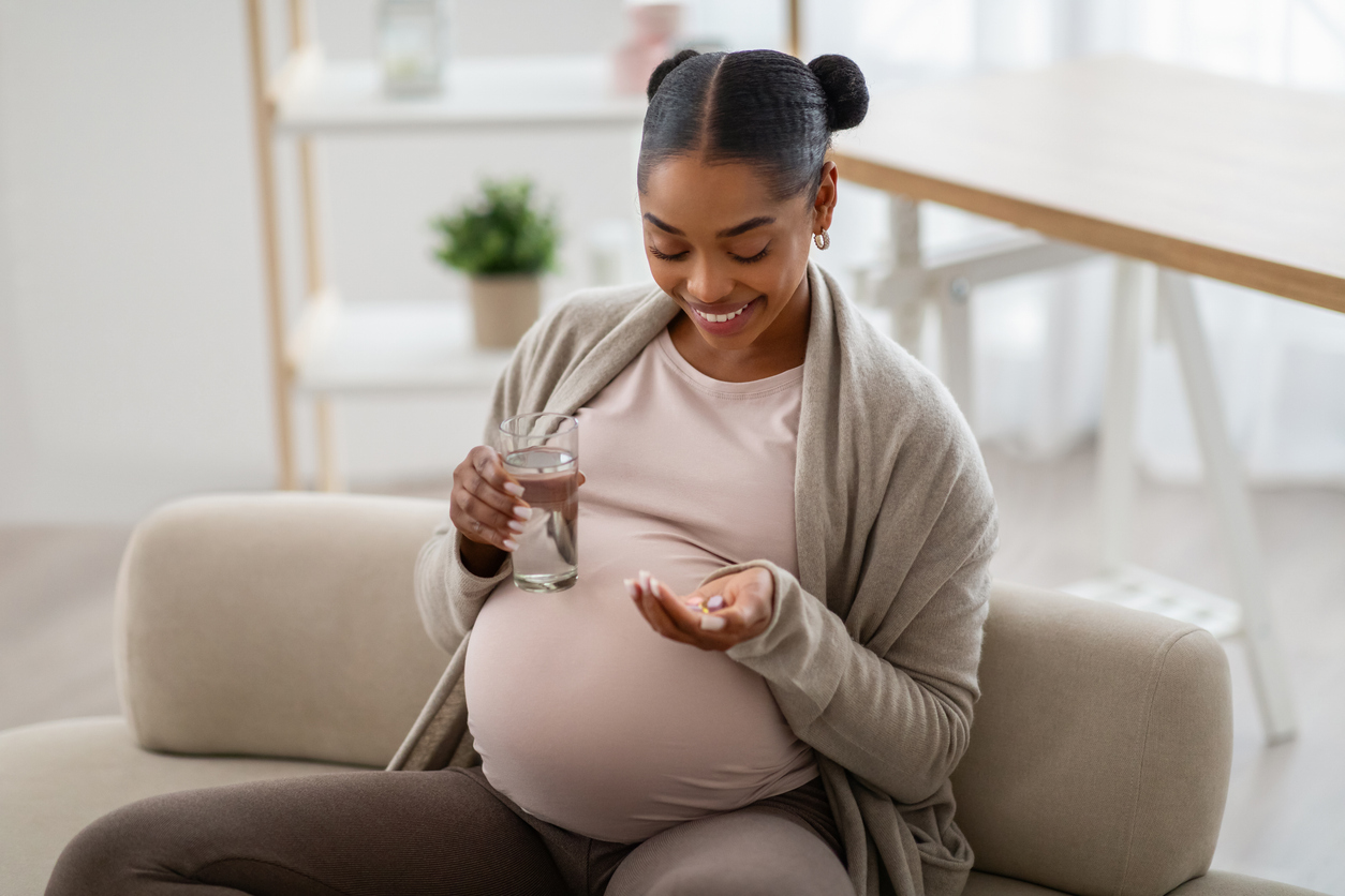 Pregnant woman taking vitamin.