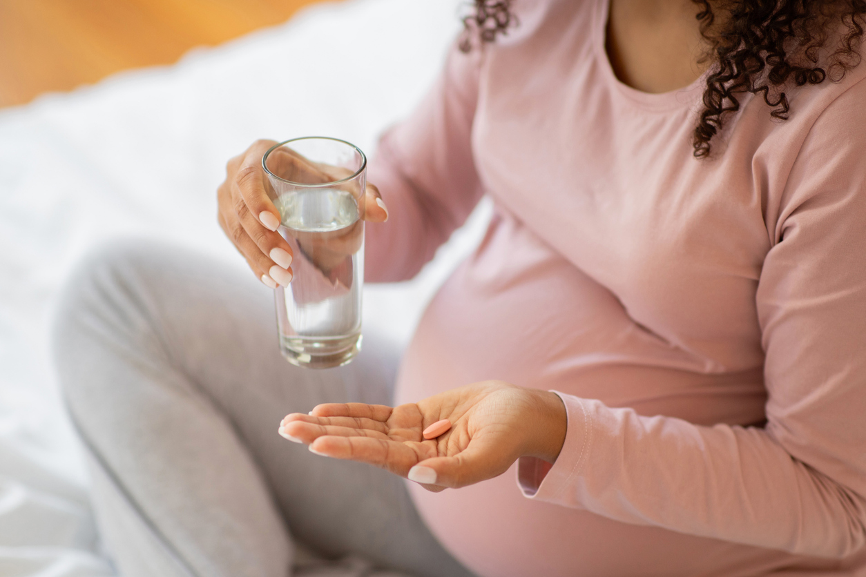 Pregnant woman taking supplement.