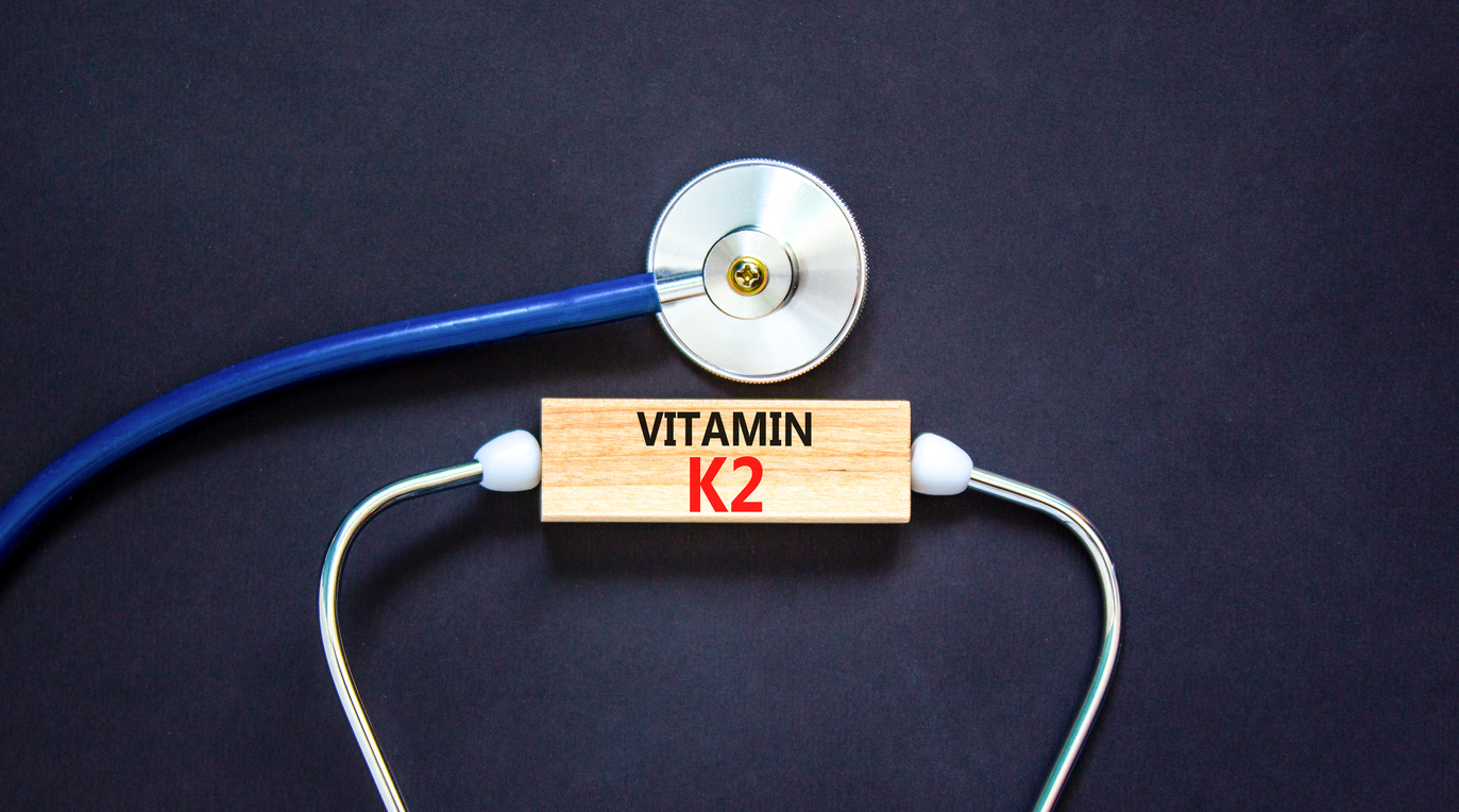 Vitamin K2 graphic with heart cutout and stethascope.